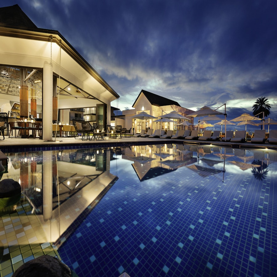 Piscine et espaces d’accueil d’un hôtel en soirée